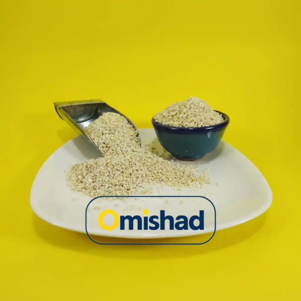 بلغور گندم اصفهان عمده 1 بخشی از بلغور گندم اصفهان عمده در بشقاب سفید با پیمانه فلزی و کاسه آبی روی زمینه زرد.