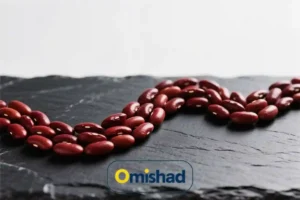 لوبیا قرمز خمین بسته 900 گرمی 4 لوبیا قرمز خمین بسته 900 گرمی امیشاد چیدهشده به شکل منحنی روی سنگ تیره با نور طبیعی.