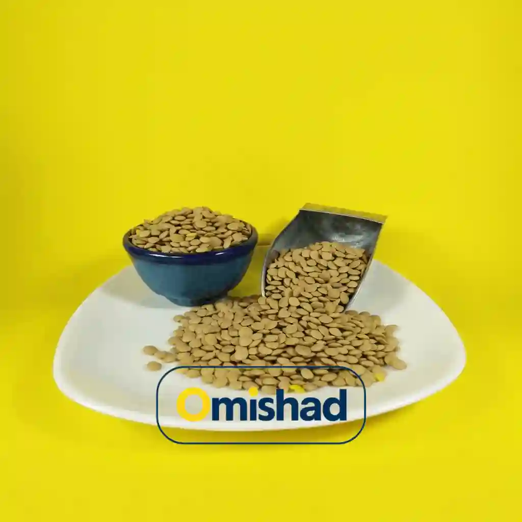 عدس خارجی روس بسته 900 گرمی 1 پیمانه فلزی و کاسه آبی پر از عدس روسی امیشاد روی بشقاب سفید با پسزمینه زرد روشن برند.