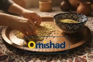 دست انسان در حال پاک‌کردن لپه ریز خارجی امیشاد روی سینی مسی سنتی کنار کاسه آبی طرح‌دار با نور گرم طبیعی.