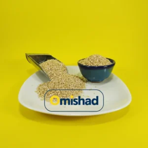 بلغور گندم بسته ۹۰۰ گرمی در کاسه آبی و پیمانه فلزی روی بشقاب سفید با پسزمینه زرد.