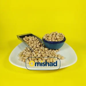 نخود درشت کرمانشاه در پیمانه فلزی و کاسه آبی روی بشقاب سفید با پس‌زمینه زرد.