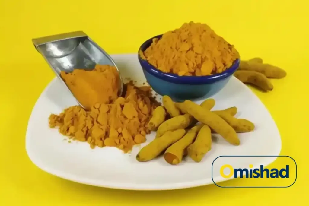 از سیر تا پیاز زردچوبه (Turmeric) راهنمای کامل خواص، قیمت و خرید امیشاد در کاسه آبی تیره و سرتاس فلزی روی بشقاب سفید همراه ریشه‌های زردچوبه خشک