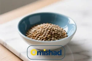 کاسه آبی سرامیکی پر از عدس درشت کانادایی امیشاد روی میز سنگی روشن در نور طبیعی روز .