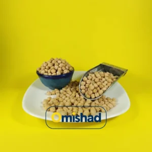 اخبار قیمت حبوبات در سه فصل سال 1403 2 نخود دوخان کرمانشاه بهصورت فله در بشقاب سفید با کاسه آبی و اسکوپ فلزی روی پسزمینه زرد.