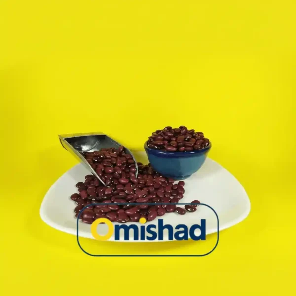 پیمانه فلزی و کاسه آبی پر از لوبیا قرمز خمین دست چین عمده 30 کیلویی دست‌چین روی بشقاب سفید با پس‌زمینه زرد برند امیشاد.