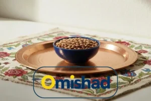 کاسه آبی حاوی عدس خارجی روس عمده 25 کیلویی امیشاد روی سینی مسی سنتی قرار گرفته بر پارچه گلدار ایرانی .