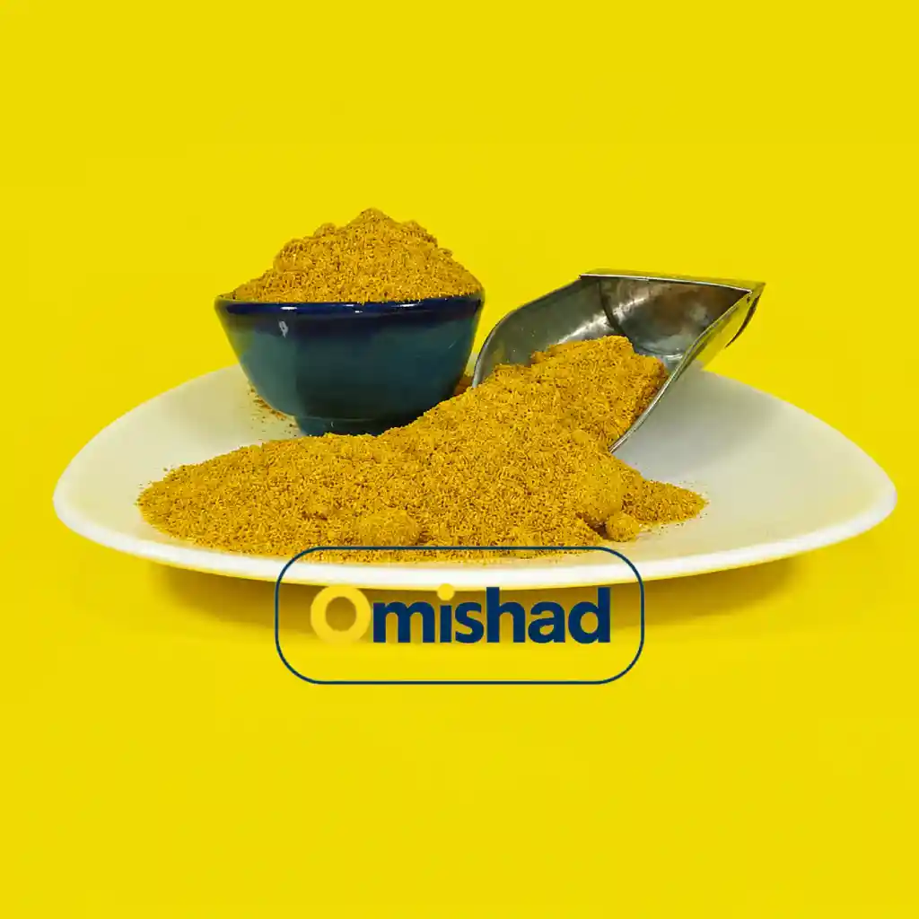 ادویه تندوری عمده و فله 20 کیلویی 1 پودر ادویه تندوری نارنجی روی بشقاب سفید، کنار کاسه سرامیکی آبی و پیمانه فلزی با پسزمینه زرد.