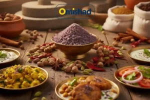 کاسه برنجی پر از بلورهای نمک سیاه هندی کالا نمک روی میز چوبی در کنار ادویه‌ها و غذاهای سنتی هند.