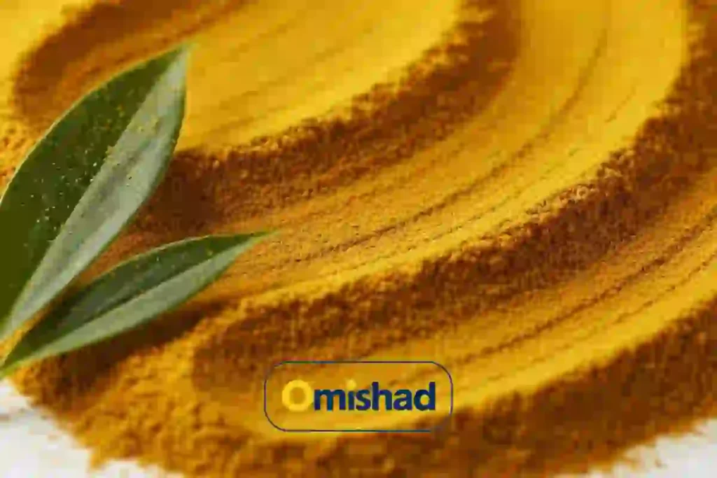 سطح موج‌دار پودر زردچوبه طلایی امیشاد با برگ سبز تازه .