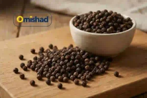 فلفل سیاه قلم 6 میل (دانه) بسته 200 گرمی 4 دانههای فلفل سیاه قلم 6 میل (دانه) بسته 200 گرمی پخششده روی تخته چوبی در کنار کاسه سفید.